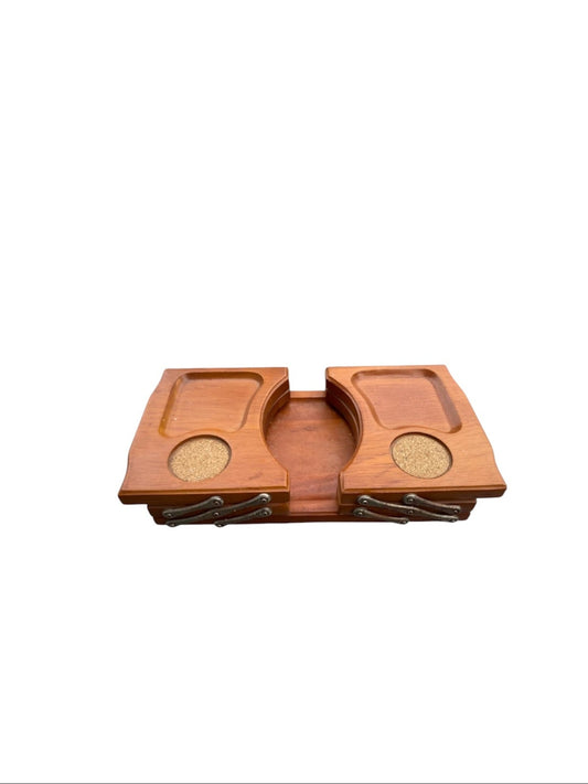 A wooden game board or tray with two raised playing areas, circular cork-like inserts, and small dark metal pieces along the bottom, shown on a plain white background.