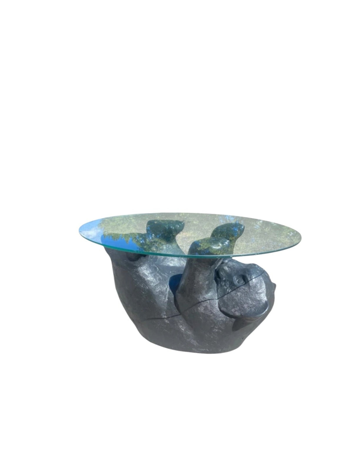 A sculptural bear-shaped coffee table with a textured dark gray base and a clear glass top, shown against a plain white background.